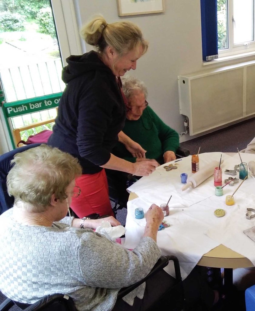 Kay Willmot stands with two clients who are enjoying creating their own decorations as keepsakes for friends 